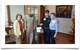 Col. Bill & Karen Tempere pose with Raqui beside Ed's book, uniform and boots